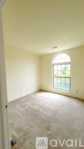 A room with a carpeted floor and a window.