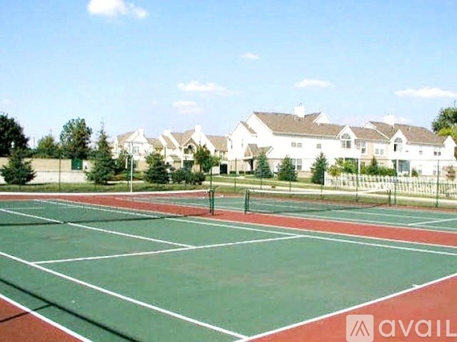A tennis court with a green and red surface and white lines.