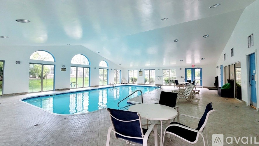 A large indoor swimming pool with a table and chairs.