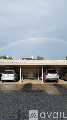 A rainbow appears over a parking garage.