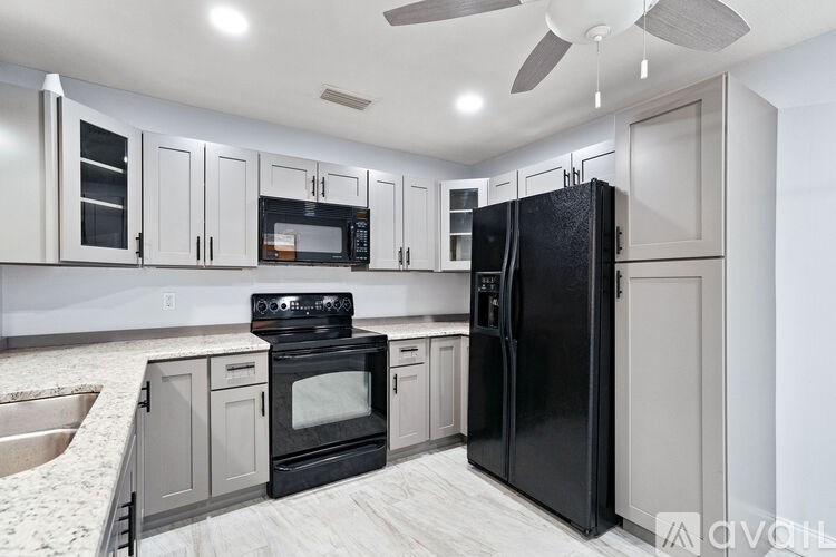 A kitchen with a black refrigerator, stove, and oven.