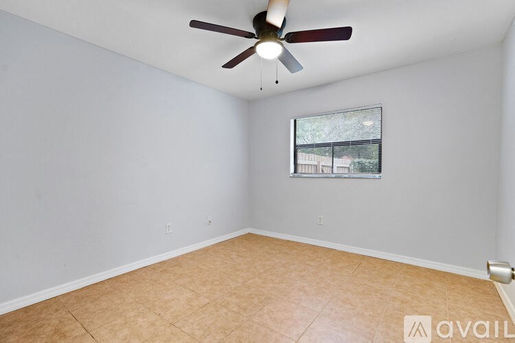 A room with a ceiling fan and a window.