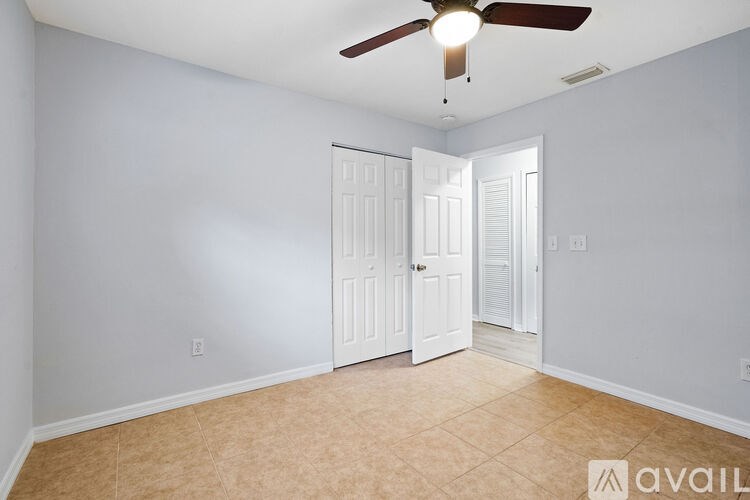 A room with a ceiling fan and two doors.