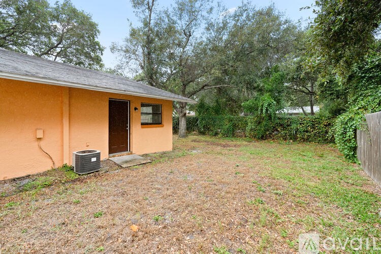 A small orange house with a brown roof and a small garden in front.