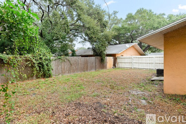 A backyard with a fence and a house in the background.