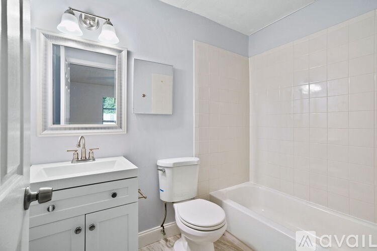 A white toilet sits next to a white sink in a bathroom.