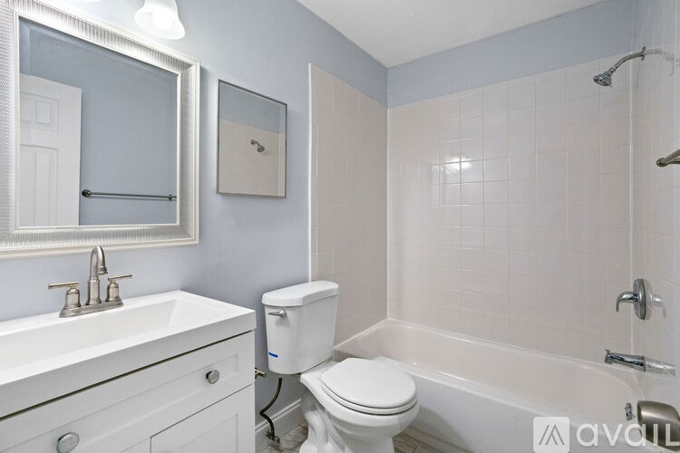 A white toilet sits next to a white sink in a bathroom.