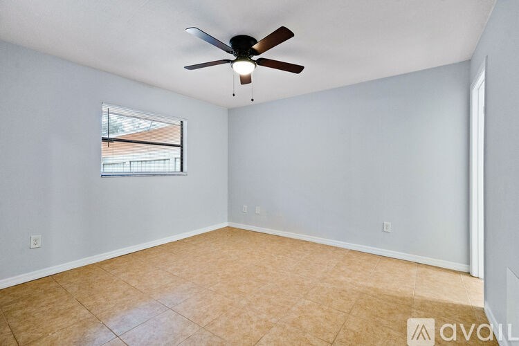 A room with a ceiling fan and a window.