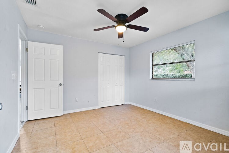 A room with a ceiling fan and a window.