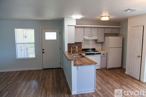A kitchen with white appliances and wooden countertops.