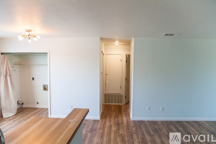 A room with a wooden floor and a door leading to a bathroom.