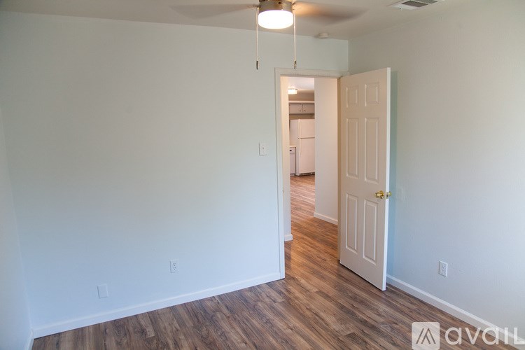 A room with a wooden floor and a ceiling fan.