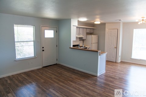 A kitchen area with a refrigerator, sink, and cabinets.