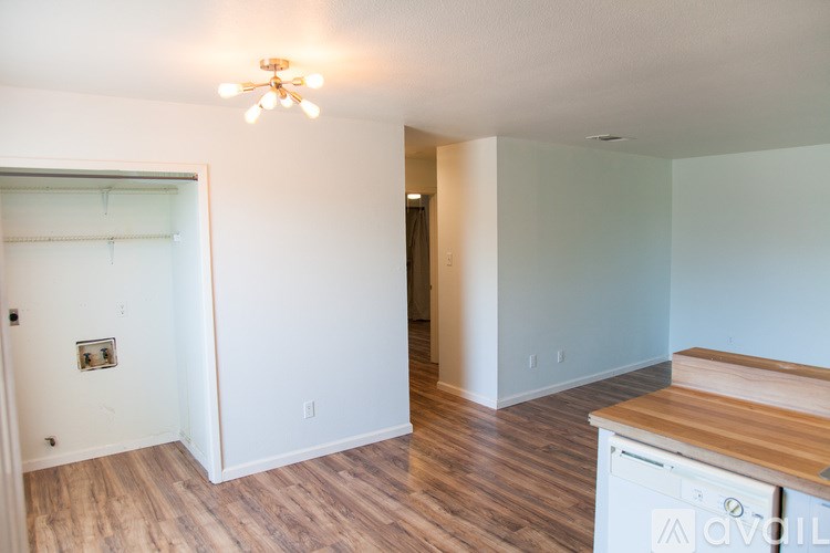 A kitchen area with a wooden counter top and a dishwasher.