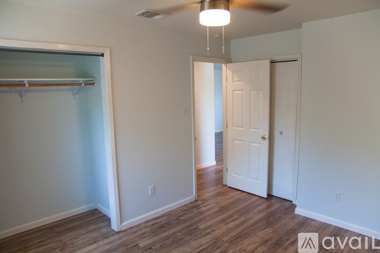 A room with a ceiling fan and a door.