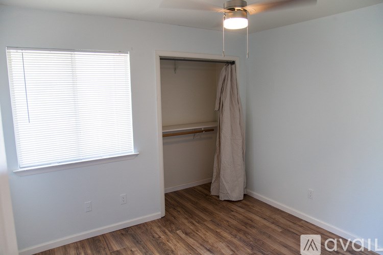 A room with a window and a hanging bedspread.