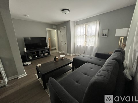 A living room with a black couch and a television.