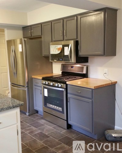 A kitchen with a stove top oven and a refrigerator.