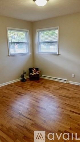 A room with wooden floors and two windows.