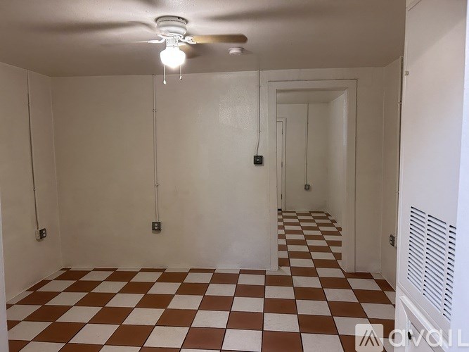 A room with a checkered floor and a ceiling fan.