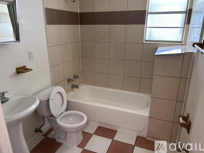 A white toilet is next to a bathtub in a bathroom.