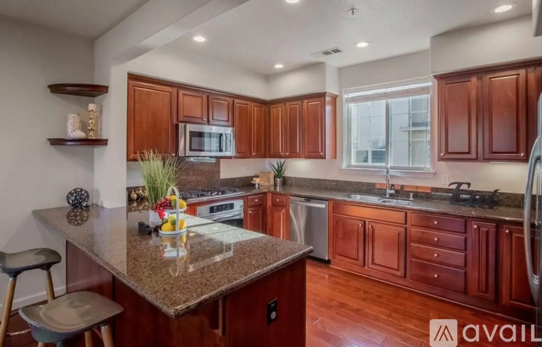 A kitchen with brown cabinets and a granite countertop.