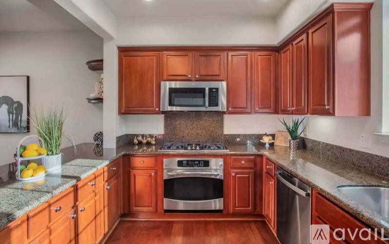 A kitchen with wooden cabinets and a granite countertop.