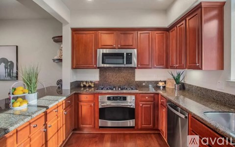 A kitchen with wooden cabinets and a granite countertop.