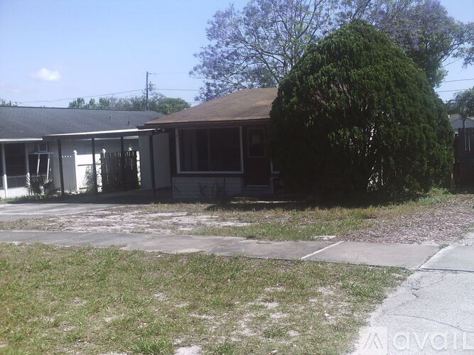 A house with a brown roof and a tree in front.