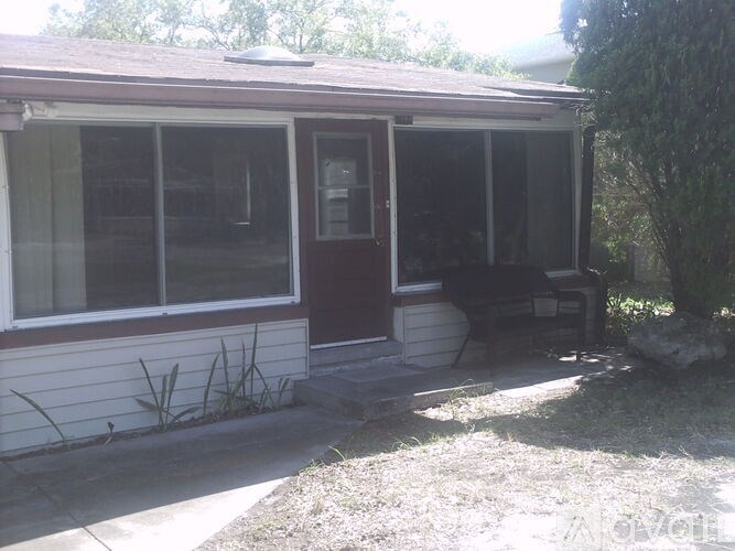 A house with a brown door and a bench outside.