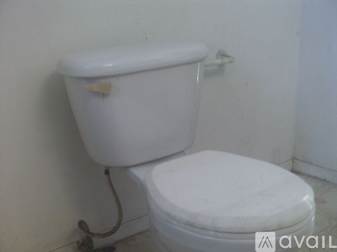 A white toilet with a white tank and a white lid.