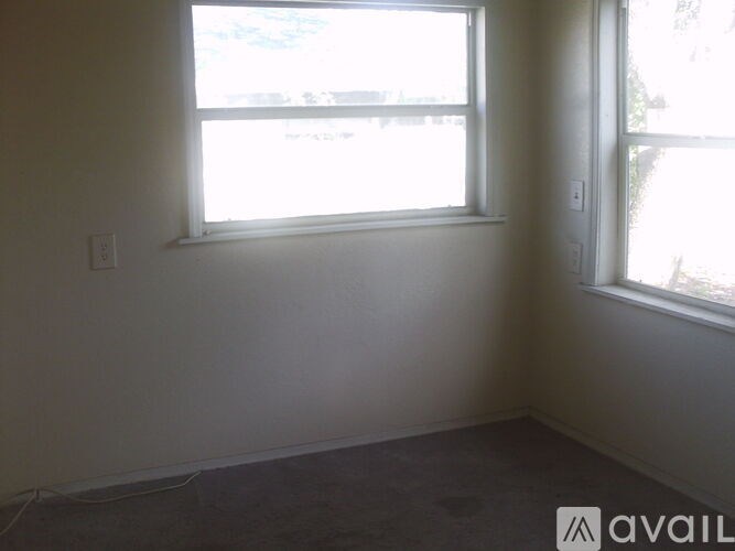 A room with a window and a wall socket.