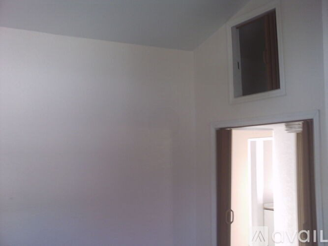 A white room with a door and a small window.