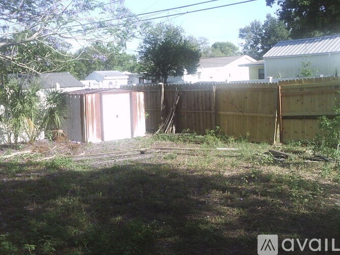 A backyard with a shed and a fence.