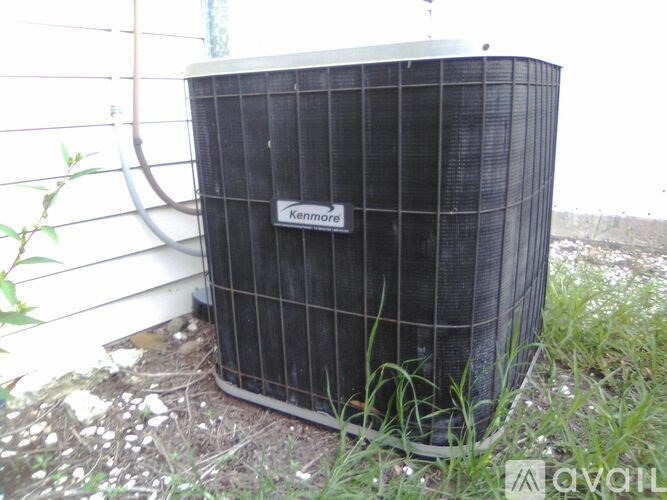 A Kenmore air conditioner unit is placed outside on the grass.