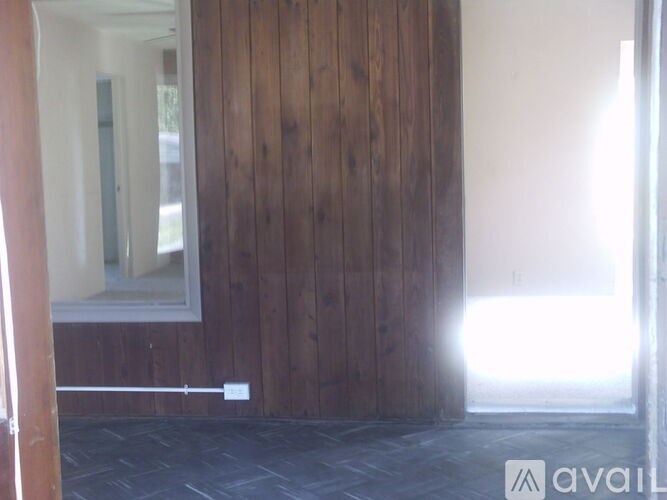 A room with wooden walls and a window.