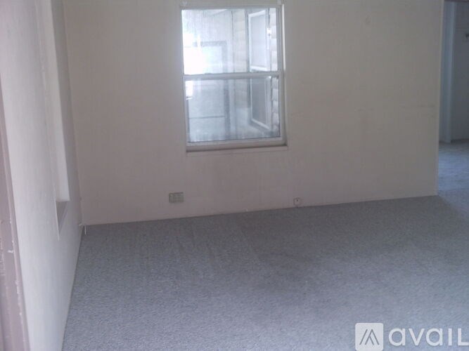 A room with a window and carpeted floor.