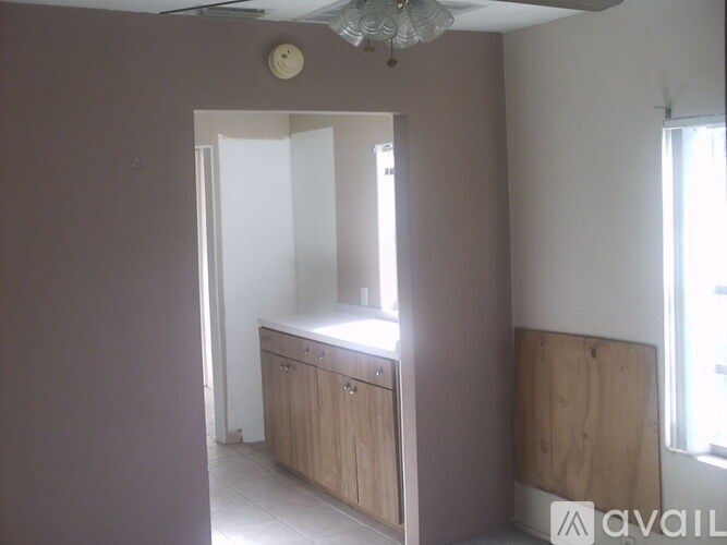A room with a cabinet and a chandelier.