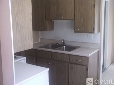 A kitchen with wooden cabinets and a white dishwasher.