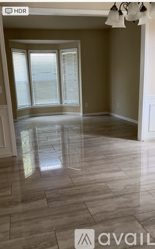 A spacious room with tiled flooring and sliding glass doors.