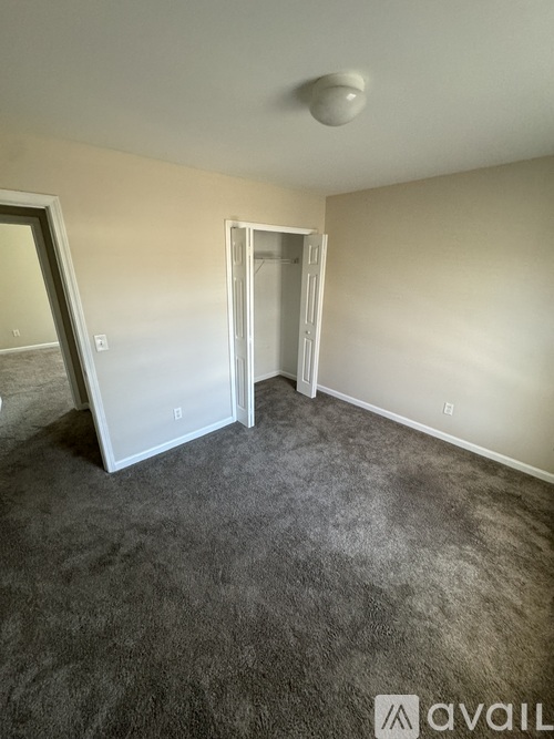 A room with a grey carpet and a white ceiling light.