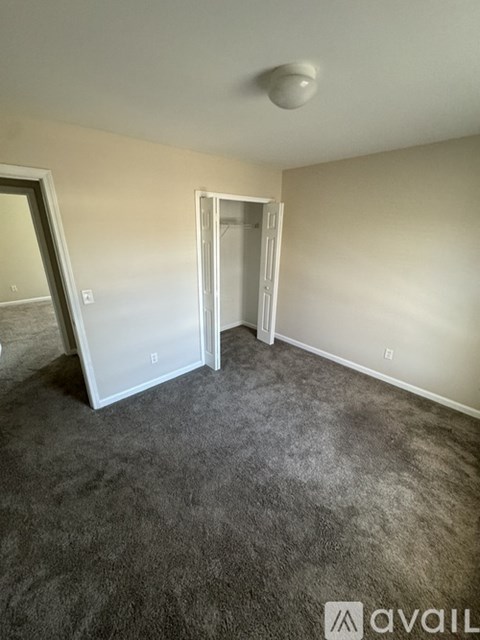 A room with a grey carpet and a white ceiling light.