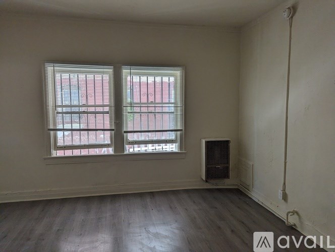 A room with two windows and a wooden floor.