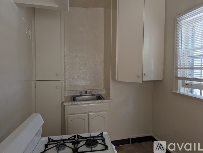A small bathroom with a white toilet, sink, and cabinets.