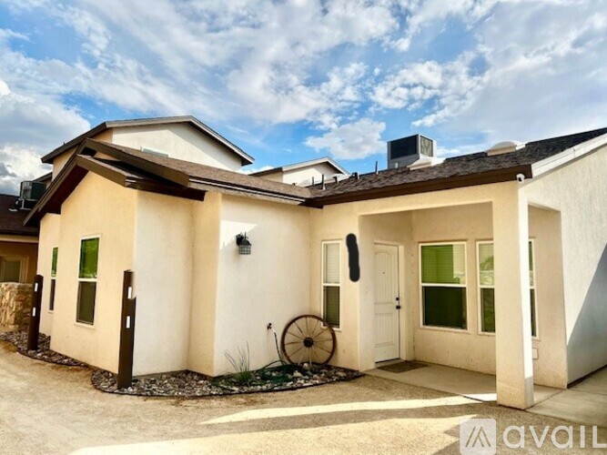 A house with a brown roof and white walls is for sale.