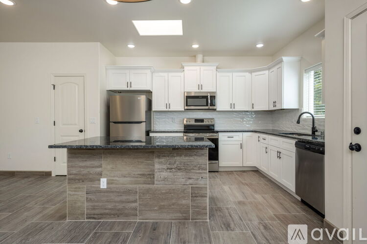 A kitchen with a stone countertop and stainless steel appliances.