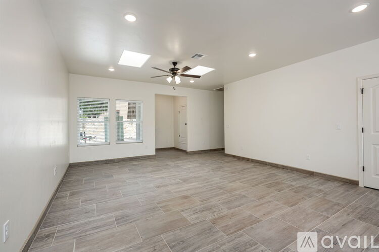 A spacious room with a ceiling fan and lighting fixtures.