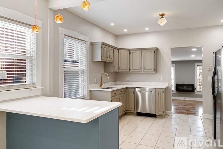 A kitchen with a white countertop and a stainless steel dishwasher.