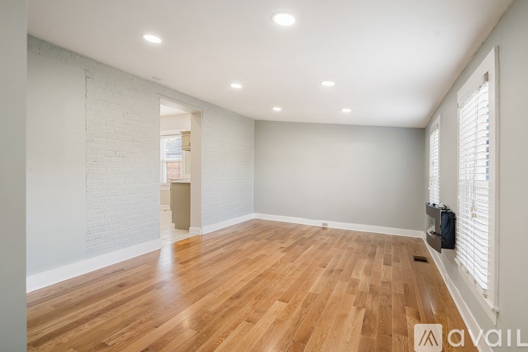 A room with wooden floors and white walls is available for rent.