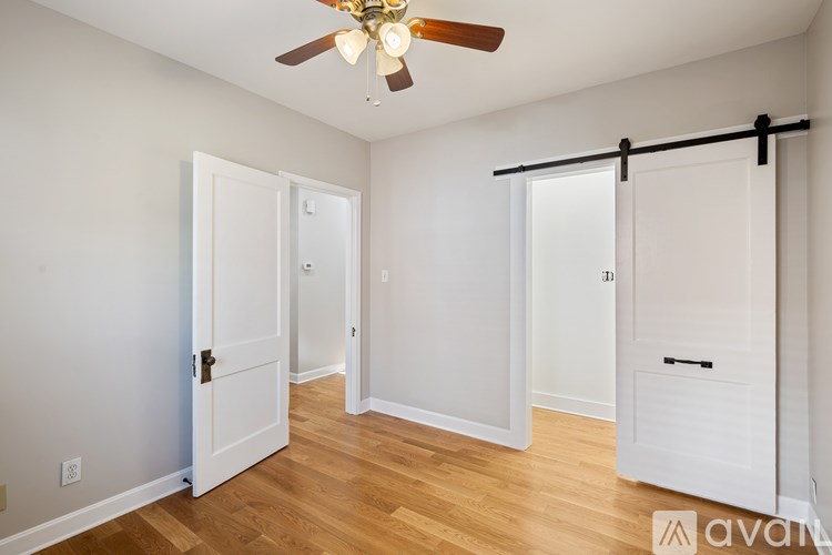 A room with a ceiling fan and sliding doors.